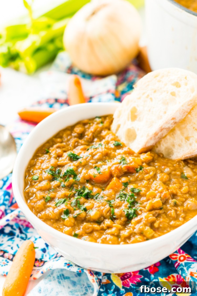 A ladle serving a generous portion of thick lentil soup into a bowl, emphasizing its rich texture.