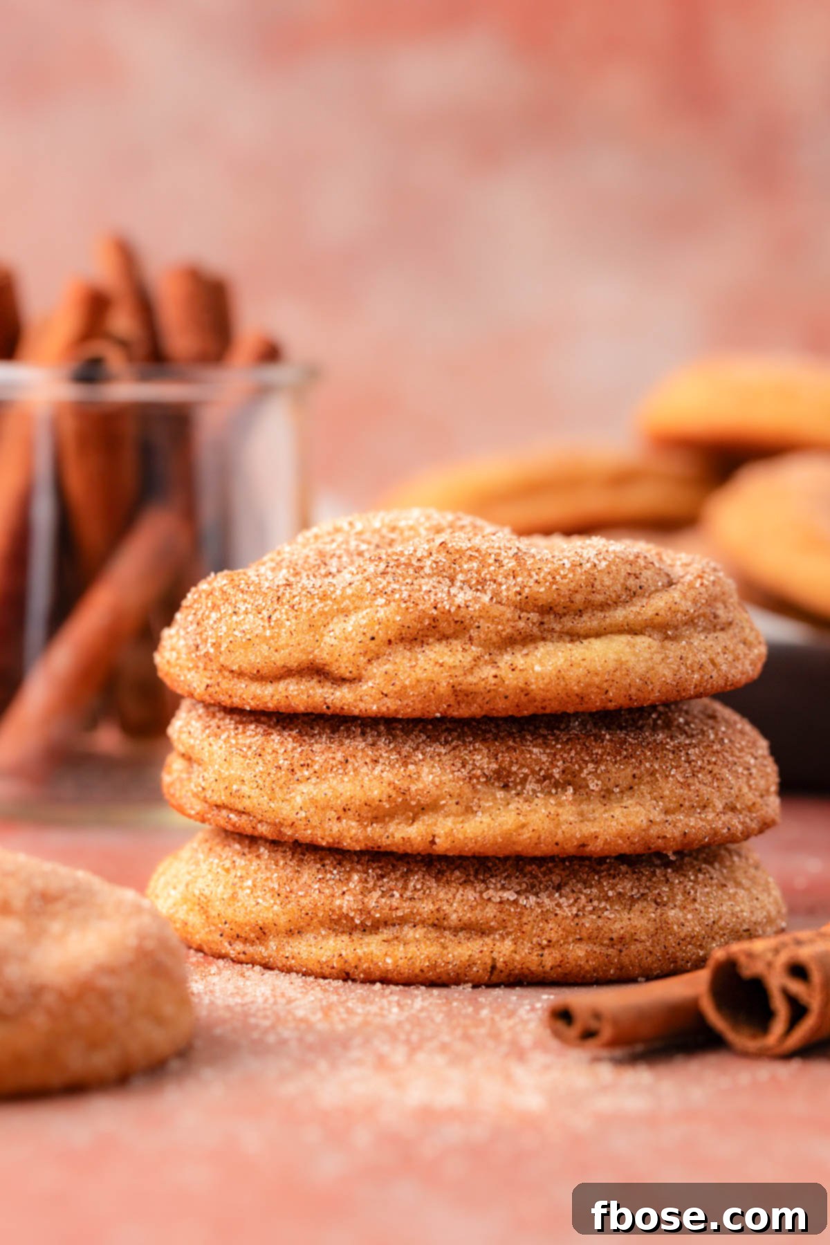 A stack of three snickerdoodle cookies on a table.