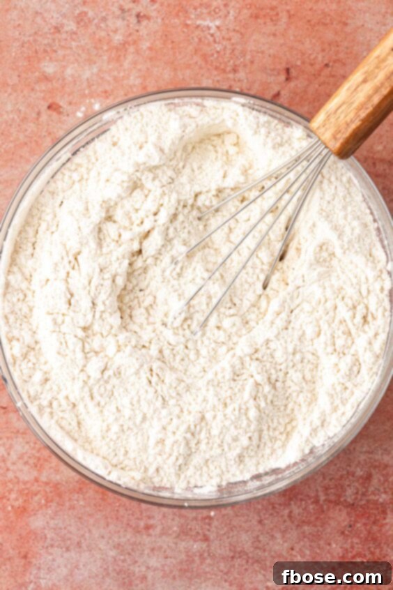 Dry ingredients for cookies being whisked in a bowl.