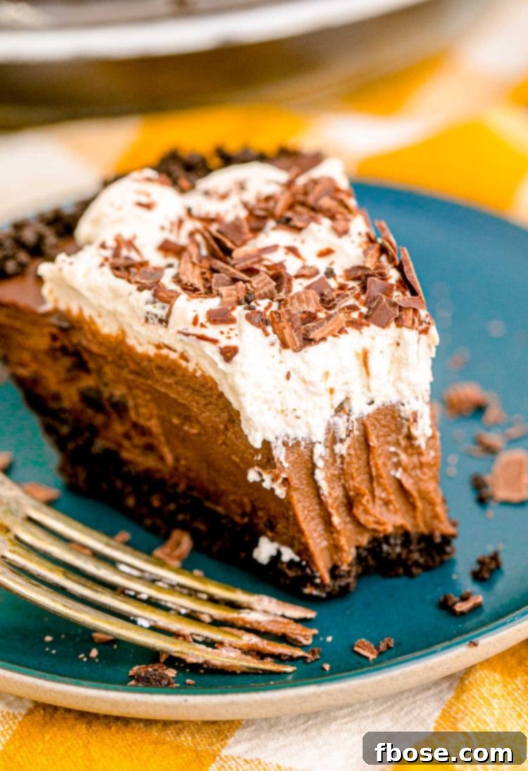Velvet Chocolate Indulgence 2 A slice of chocolate cream pie on a blue plate with a bite missing from it.