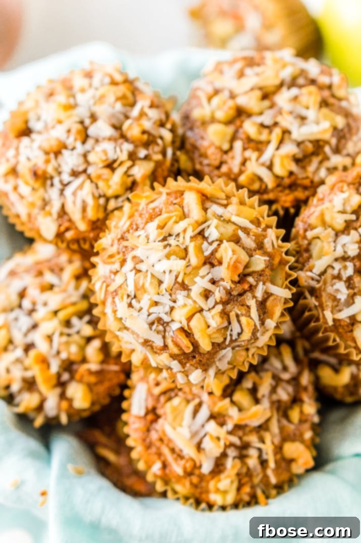Up-close shot of a freshly baked Morning Glory Muffin, highlighting the texture and visible wholesome ingredients like craisins, carrots, and walnuts.