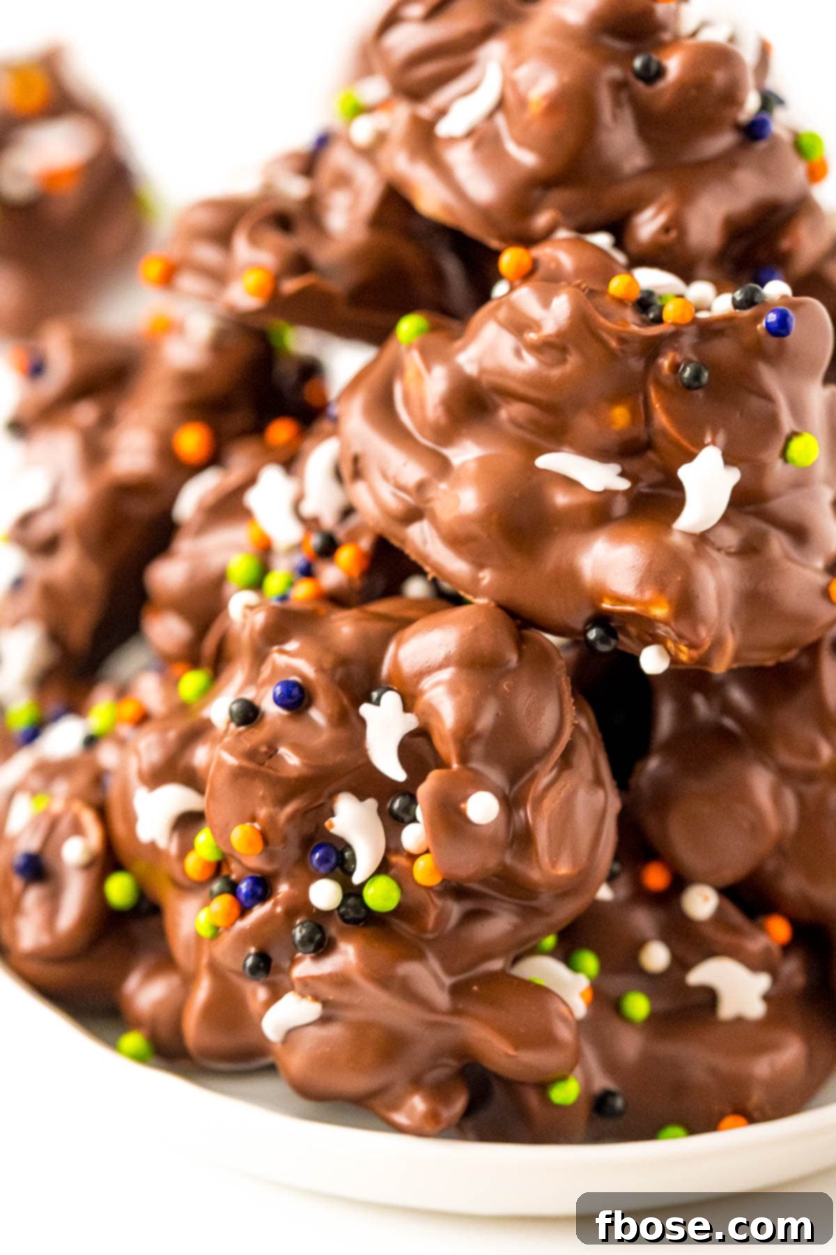 Chocolate candies with halloween sprinkles on a white plate.
