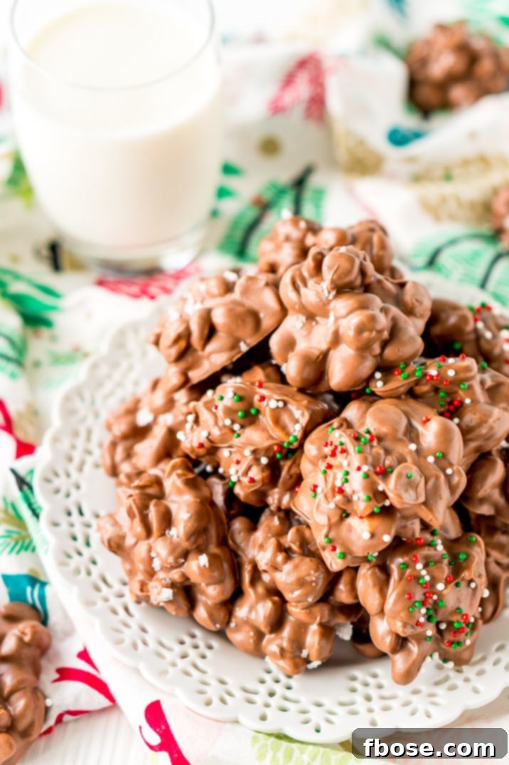 Crockpot Candy is loaded with peanuts, almond bark, and lots of chocolate and super easy to make in the slow cooker! Topped with some festive sprinkles, this pop-in-your-mouth treat is perfect for sharing during the holiday season.