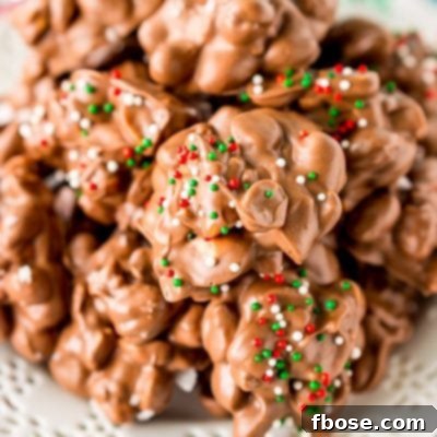 Crockpot Candy is loaded with peanuts, almond bark, and lots of chocolate and super easy to make in the slow cooker! Topped with some festive sprinkles, this pop-in-your-mouth treat is perfect for sharing during the holiday season.