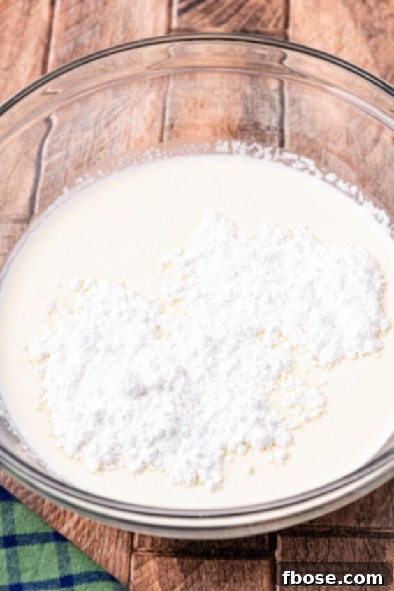 Heavy cream and powdered sugar in a bowl ready to be whipped.