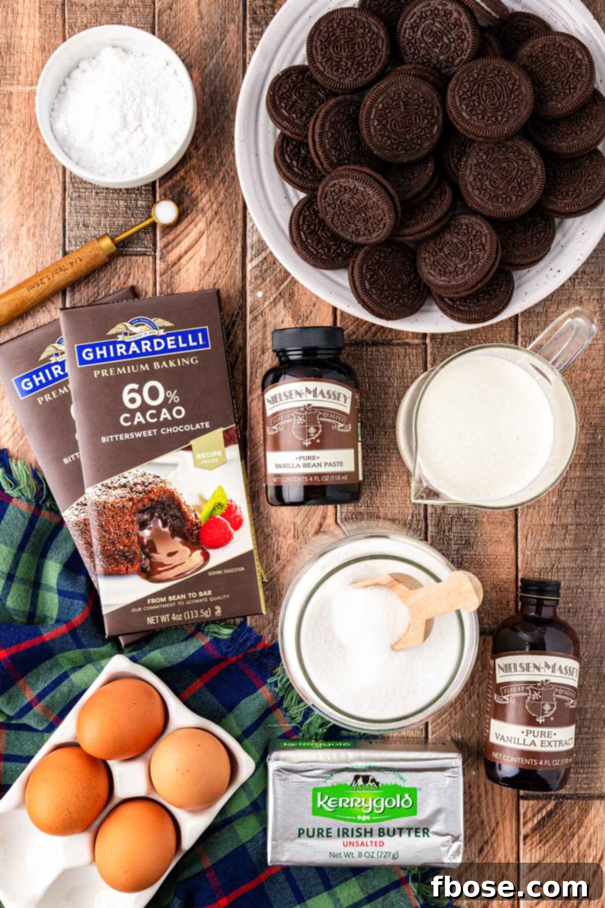 Overhead photo of various ingredients to make French Silk Pie, including chocolate, butter, and Oreos, arranged on a wooden table.