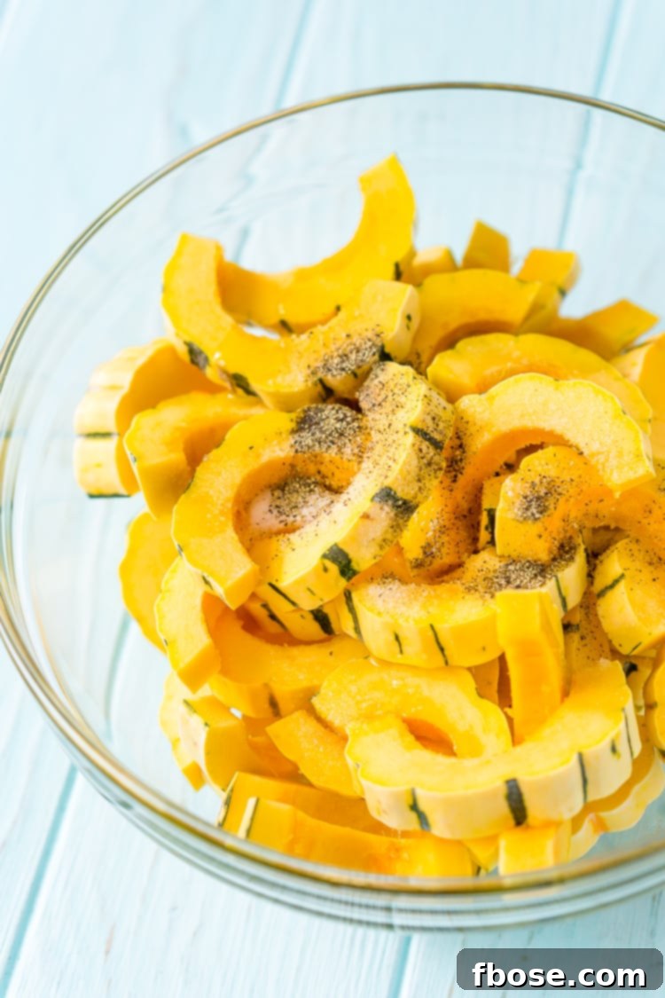 Sweet Roasted Delicata Squash 7 Delicata squash slices coated in seasoning in a mixing bowl.