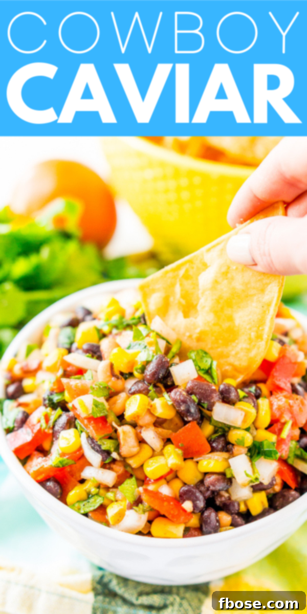 A high-angle shot of a generously filled bowl of Cowboy Caviar, showcasing the vibrant colors and fresh ingredients like beans, corn, peppers, tomatoes, and cilantro. It’s a perfect visual representation of this healthy and flavorful Mexican-inspired dip.