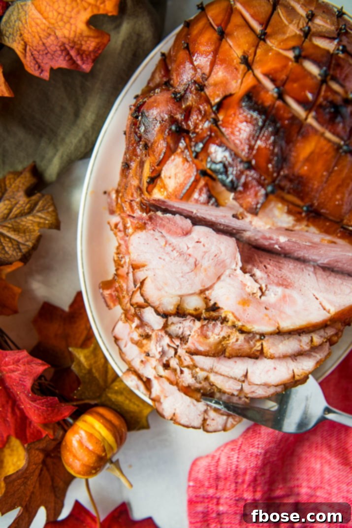 A beautifully glazed holiday ham, glistening with maple glaze, ready to be served as the perfect centerpiece.