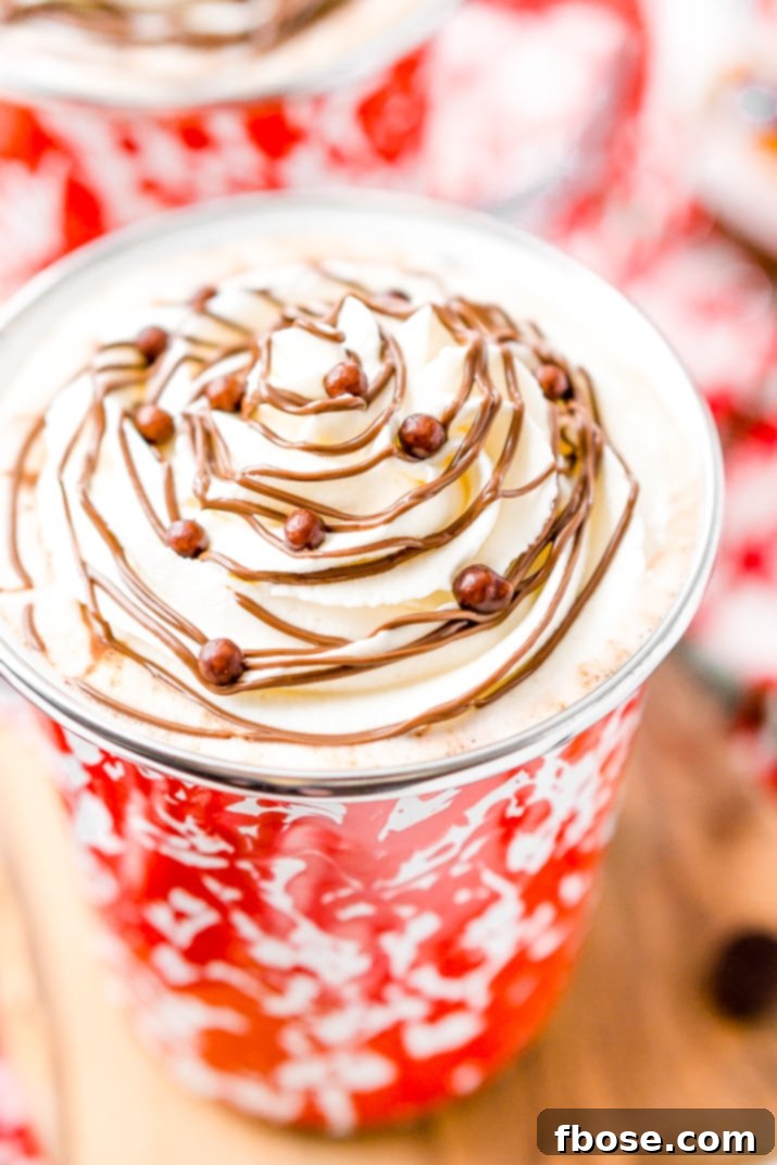 Close-up of a steaming mug of Nutella Hot Chocolate, showing its rich, thick texture, with a spoon inside.