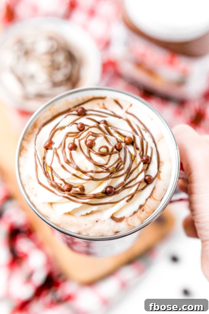 An array of toppings for a DIY hot chocolate bar, including whipped cream, marshmallows, and various chocolates.