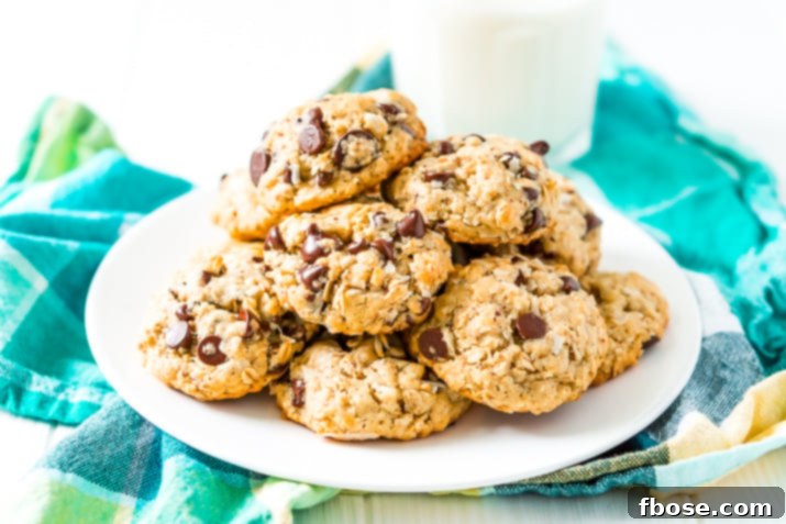 Lactation Cookies on a white plate on a blue and green napkin with a glass of milk in the background.