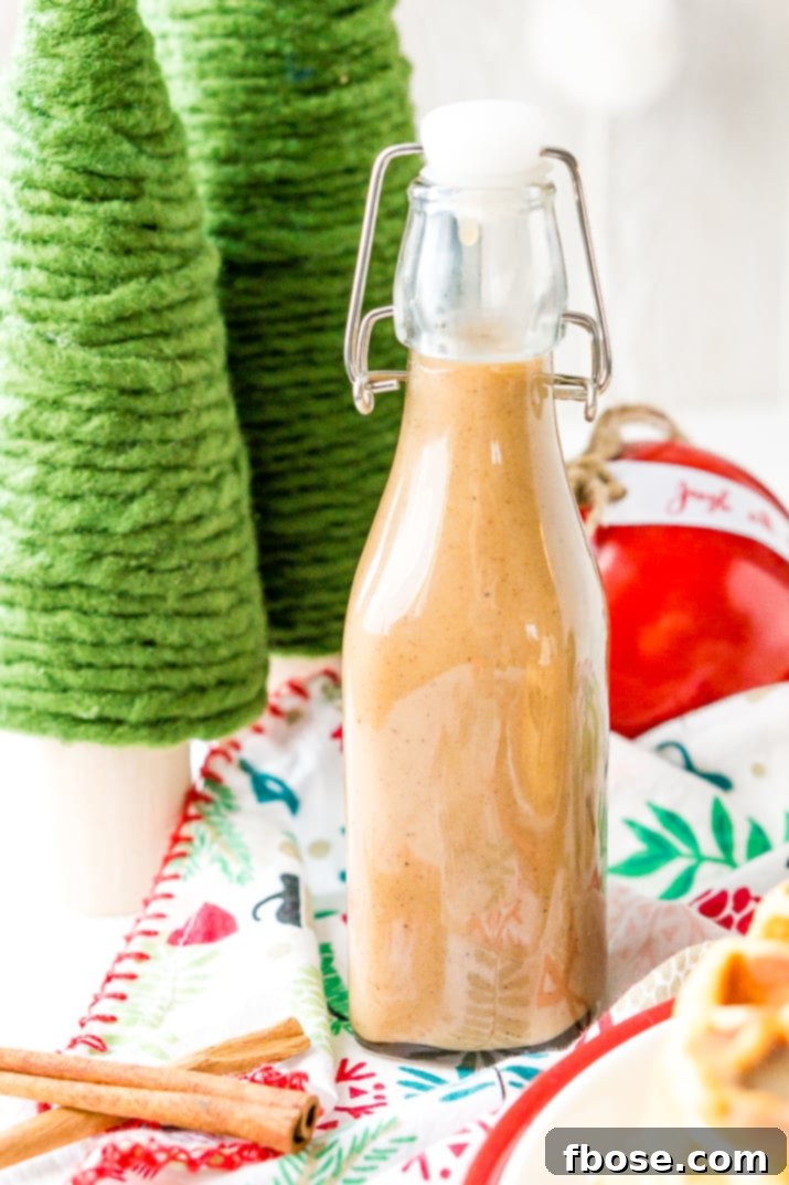 Rich, homemade Spiced Vanilla Syrup drizzled over fluffy pancakes, showcasing its creamy texture and warm, inviting color. Ideal for a cozy holiday brunch or special breakfast.