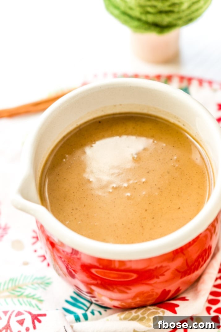Several jars of homemade Spiced Vanilla Syrup, adorned with festive ribbons, suggest it's a perfect gift. The rich, golden brown color of the syrup is highlighted.