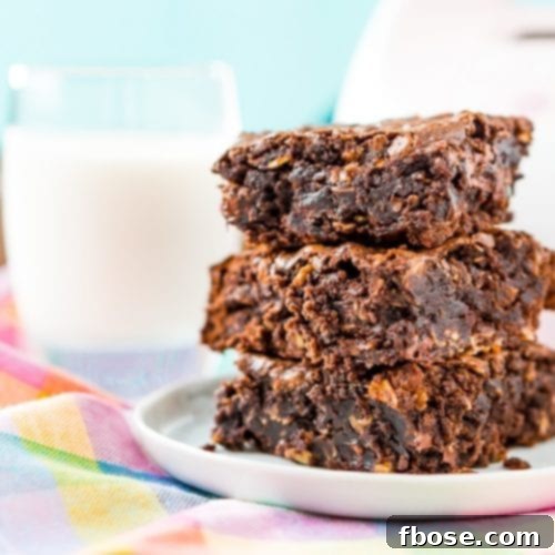 Three Lactation Brownies stacked on a plate in front of a glass of milk