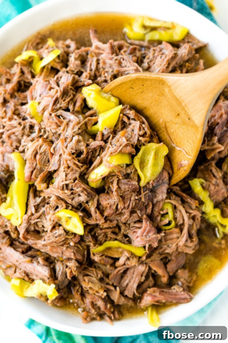 Italian Beef in white bowl with wooden spoon