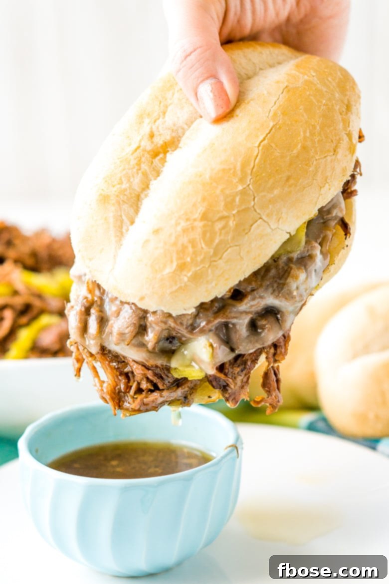 Italian beef Sandwich being dipped in au jou
