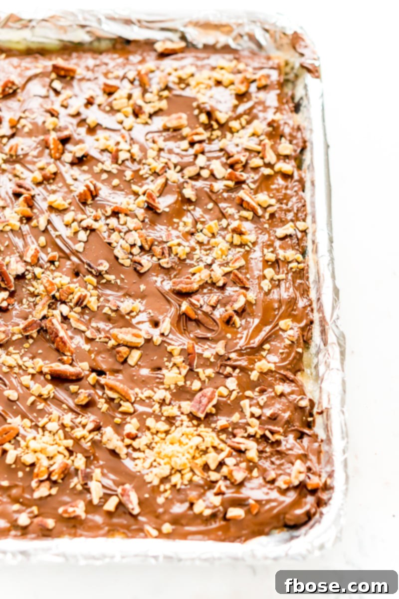 Chocolate and nuts on shortbread cookies on foil lined pan.
