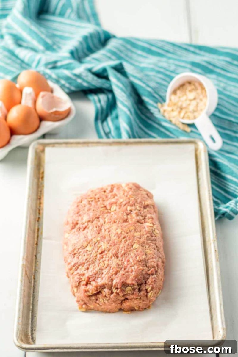 Meatloaf ingredients laid out: ground beef, oatmeal, milk, egg, onion, ketchup, salt, and pepper.
