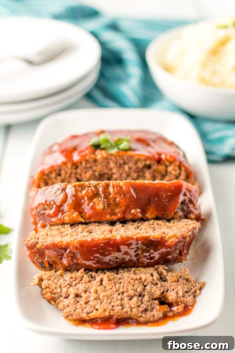 A slice of meatloaf on a plate, highlighting the delicious glaze.