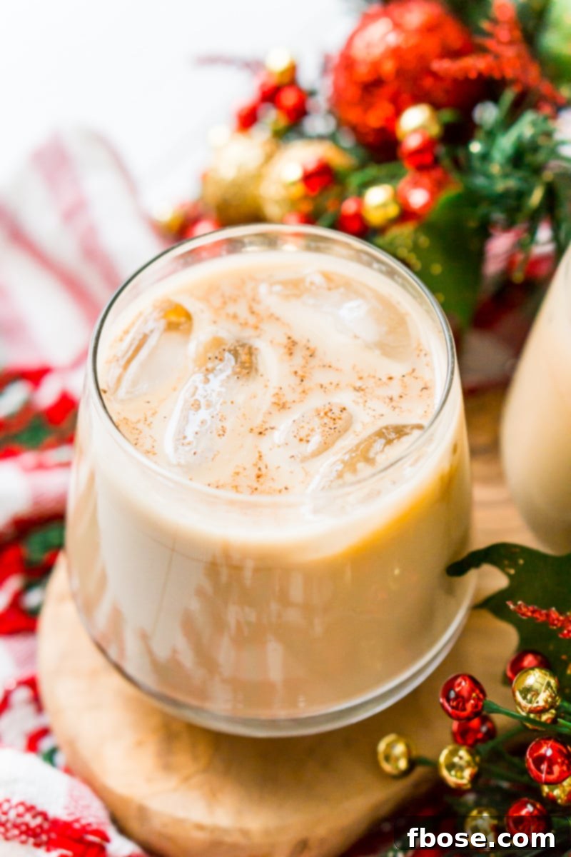 A close-up of a festive Eggnog White Russian with a cinnamon stick garnish, perfect for holiday celebrations.