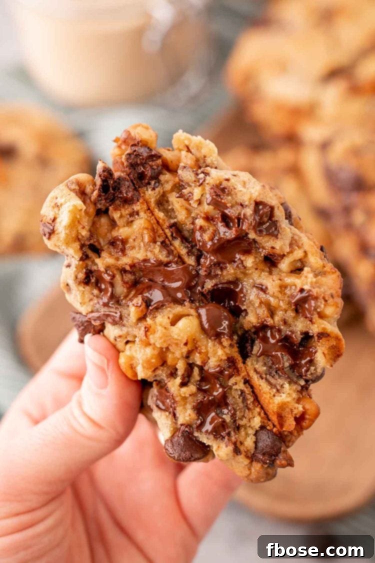 Close up photo of a Levain copycat cookie that has been broken in half revealing the soft gooey center.
