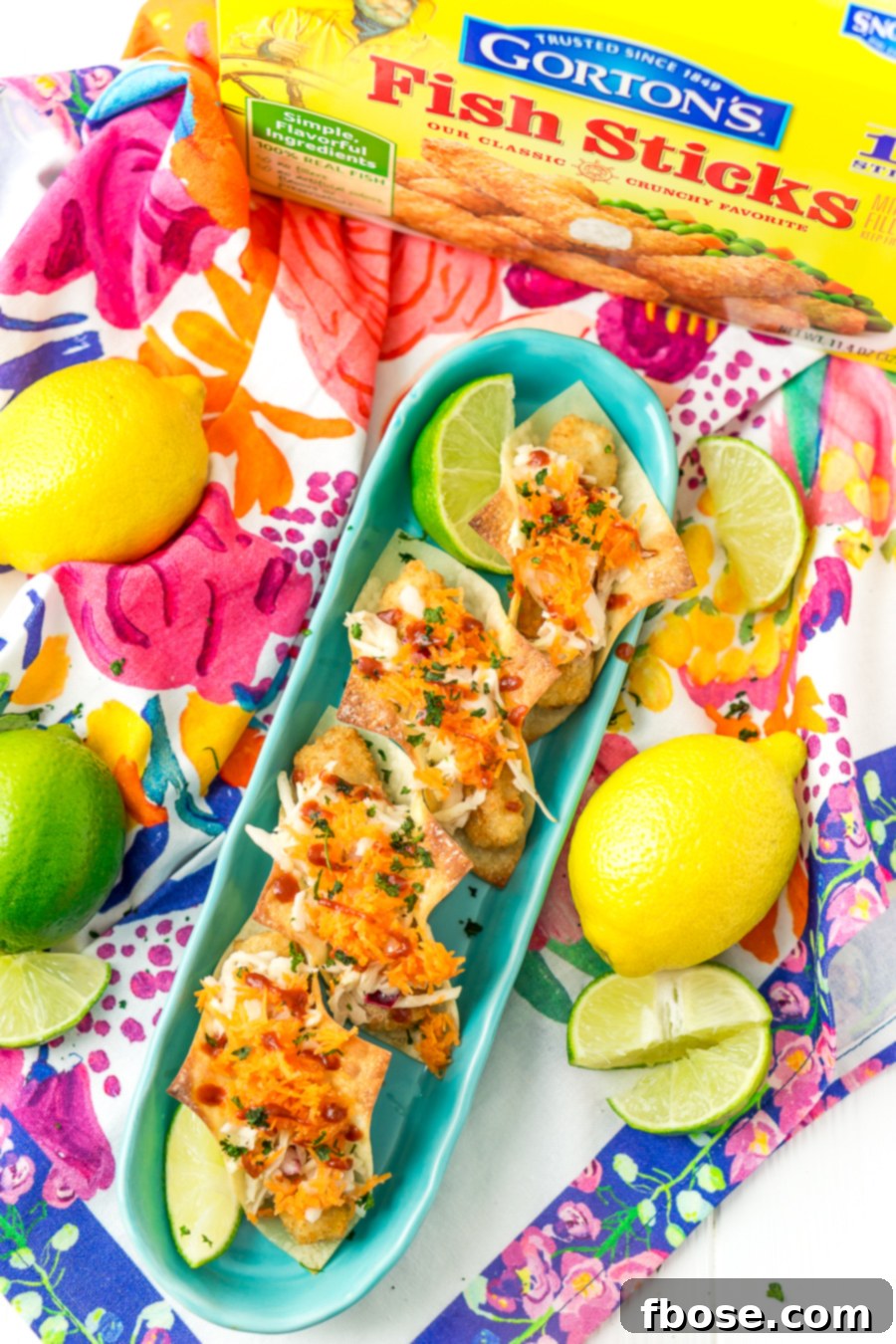 A close-up of crispy Fish Stick Wonton Tacos with vibrant slaw and sauce, ideal for easy entertaining.