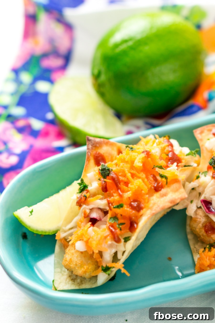 Hand holding a Fish Stick Wonton Taco, highlighting the snackable size and appealing texture.