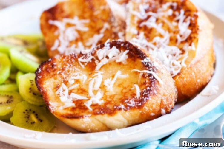Coconut Dream Toast 3 Close-up of golden brown Coconut French Toast slices, garnished with shredded coconut