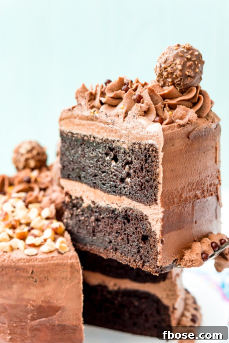 A serving of hazelnut chocolate cake being carefully lifted from the main cake on a stand, showcasing the perfect slice.