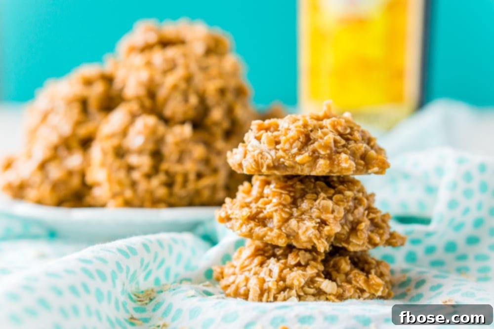 Stack of three Kahlua No Bake Cookies with plate of cookies and bottle of Kahlua in background.
