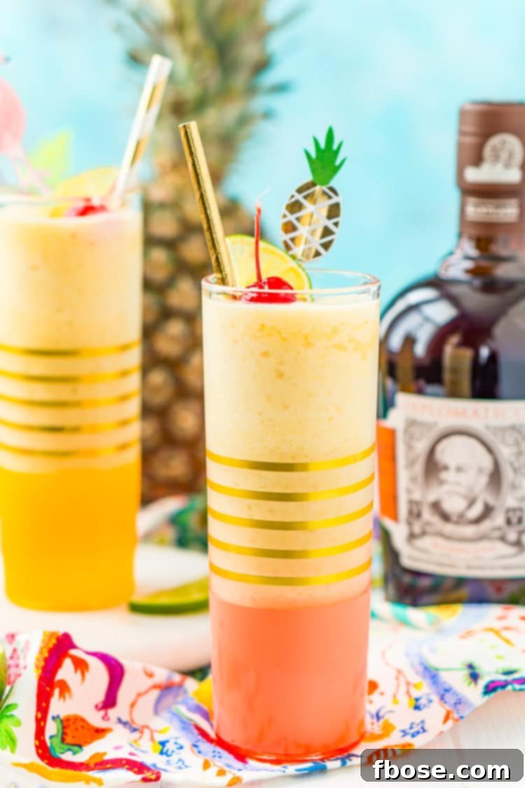 Tropical Pineapple Daiquiri 3 A glass filled with a frosty pineapple daiquiri cocktail, elegantly garnished with a fresh lime wedge, a bright maraschino cherry, and a stylish drink pick, highlighting its refreshing appeal.