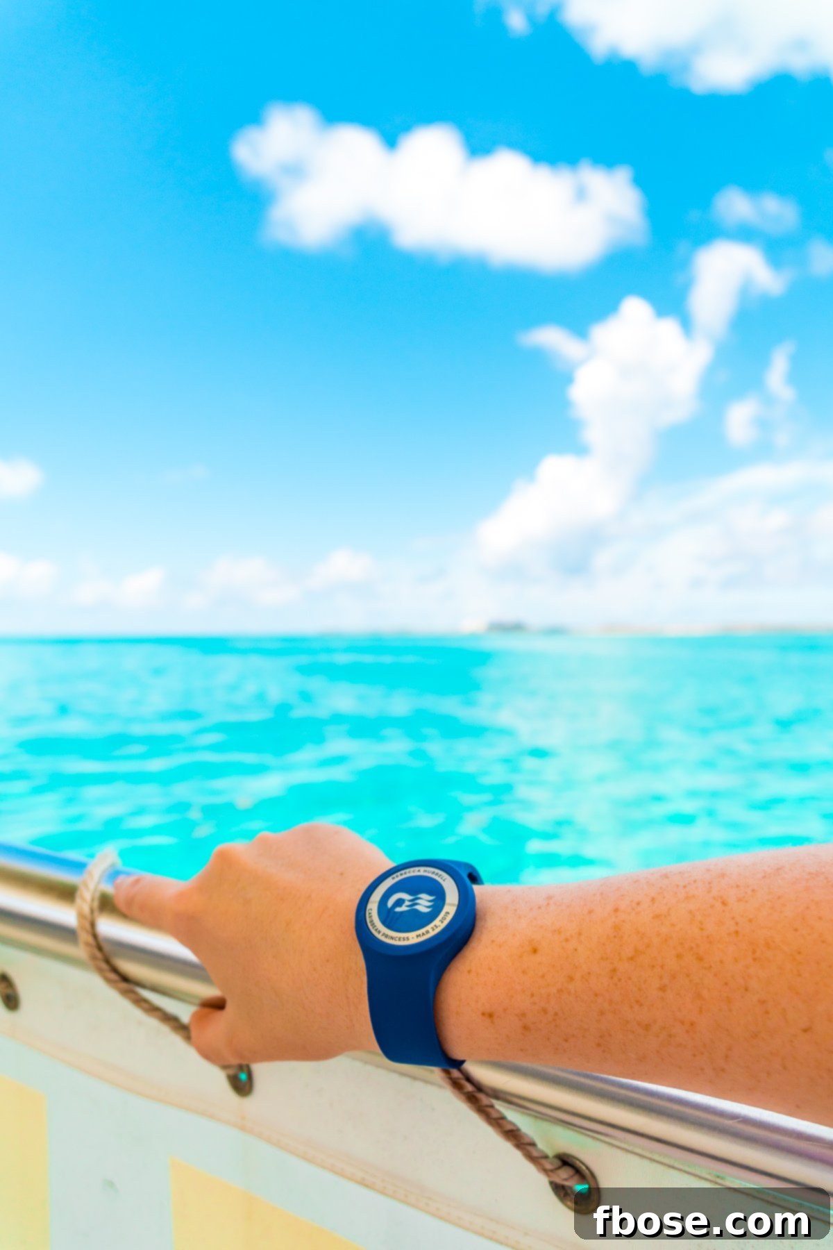 Grand Turk Island: Your Port Adventure Guide 15 A woman's arm, adorned with a Princess Cruises Ocean Medallion watch, rests on the railing of a boat, overlooking the breathtaking expanse of the Caribbean Sea.