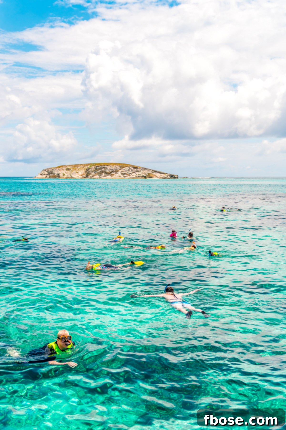 Grand Turk Island: Your Port Adventure Guide 6 A group of people are seen snorkeling in the exceptionally clear, turquoise waters of Grand Turk, Caribbean. The vibrant underwater world is visible beneath them.