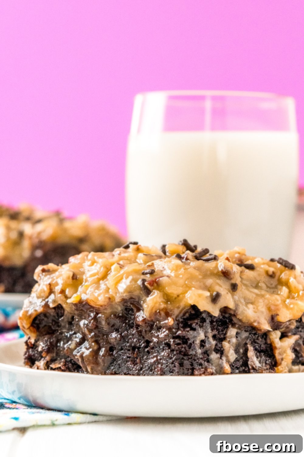This German Chocolate Poke Cake takes the classic dessert recipe to a whole new level with a tender chocolate cake soaked in sweetened condensed milk and topped with a rich chocolate ganache and sweet coconut pecan frosting!