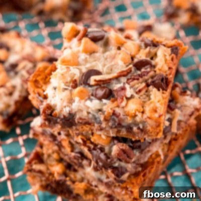 Seven-Layer Magic Bars 7 Close up photo of Hello Dolly Bars stacked on a copper wire rack.