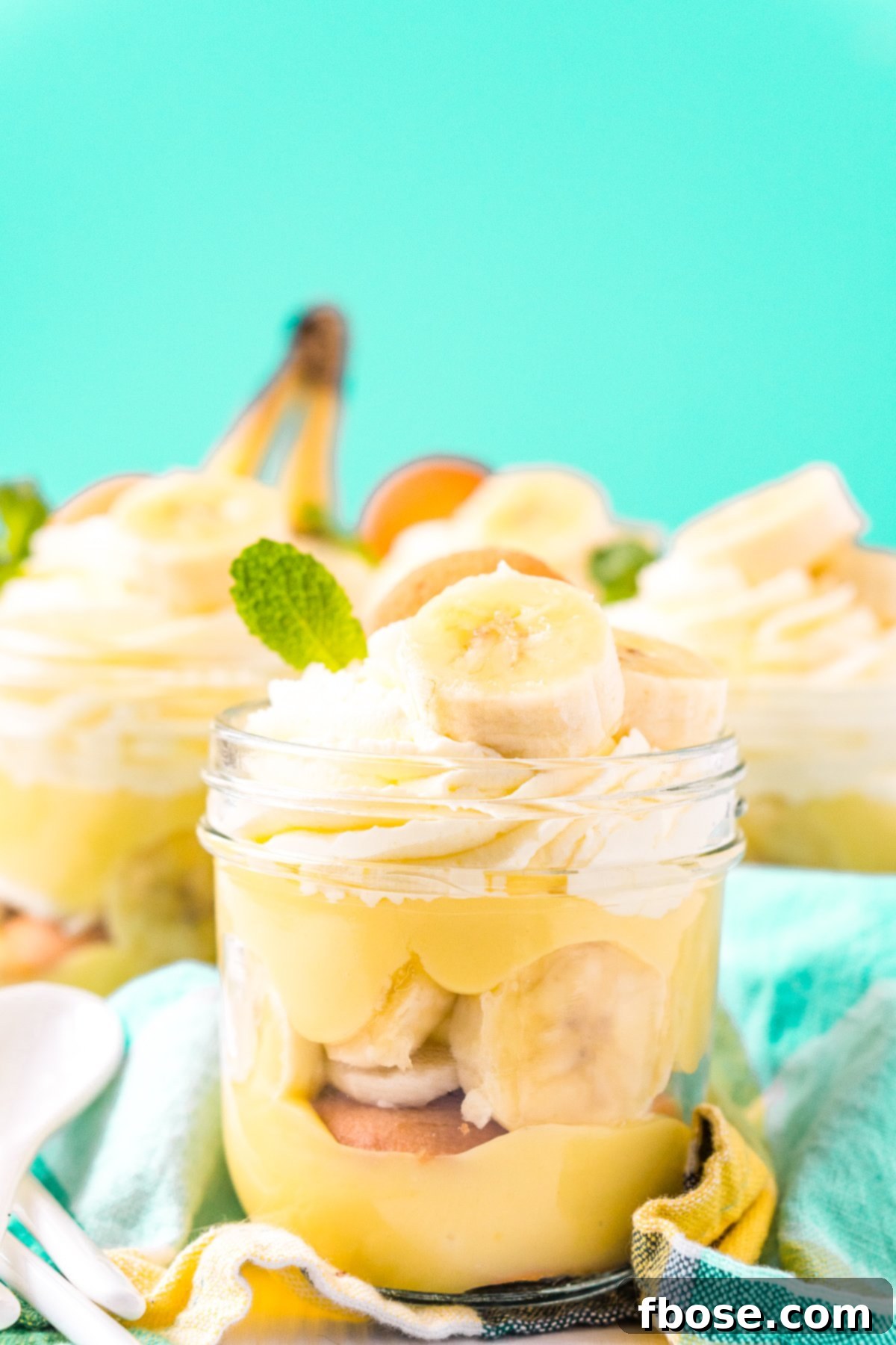 Jars of banana pudding on a blue napkin.