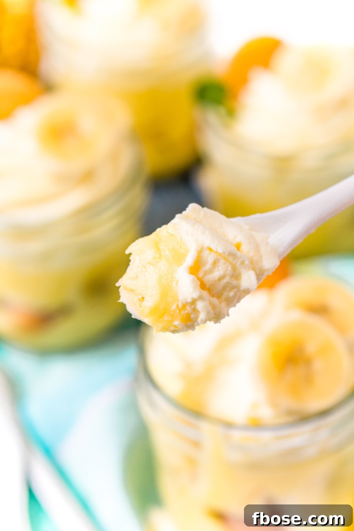 Spoonful of banana pudding with jars of pudding in the background.