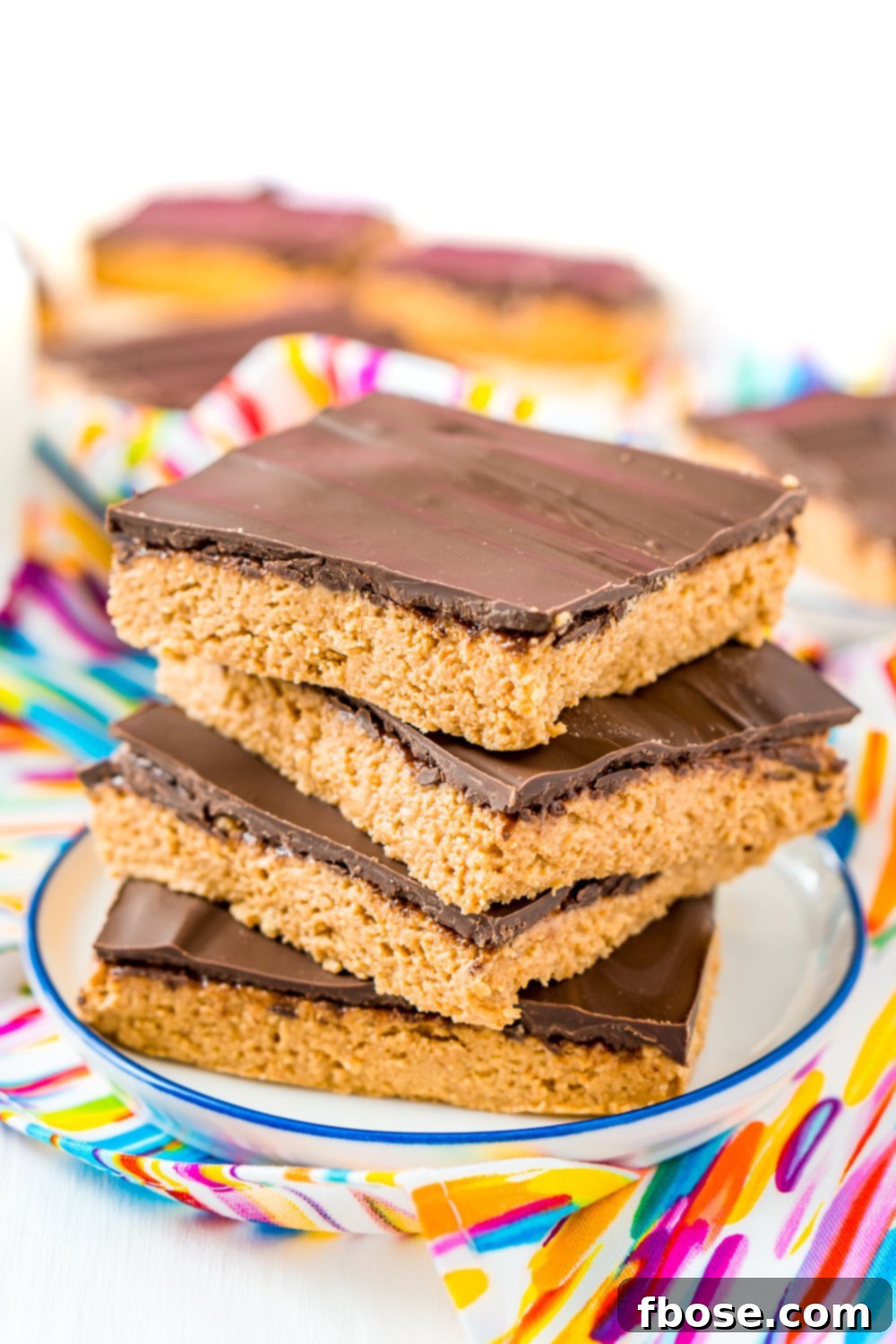 Stack of 4 peanut butter bars on a small white plate.