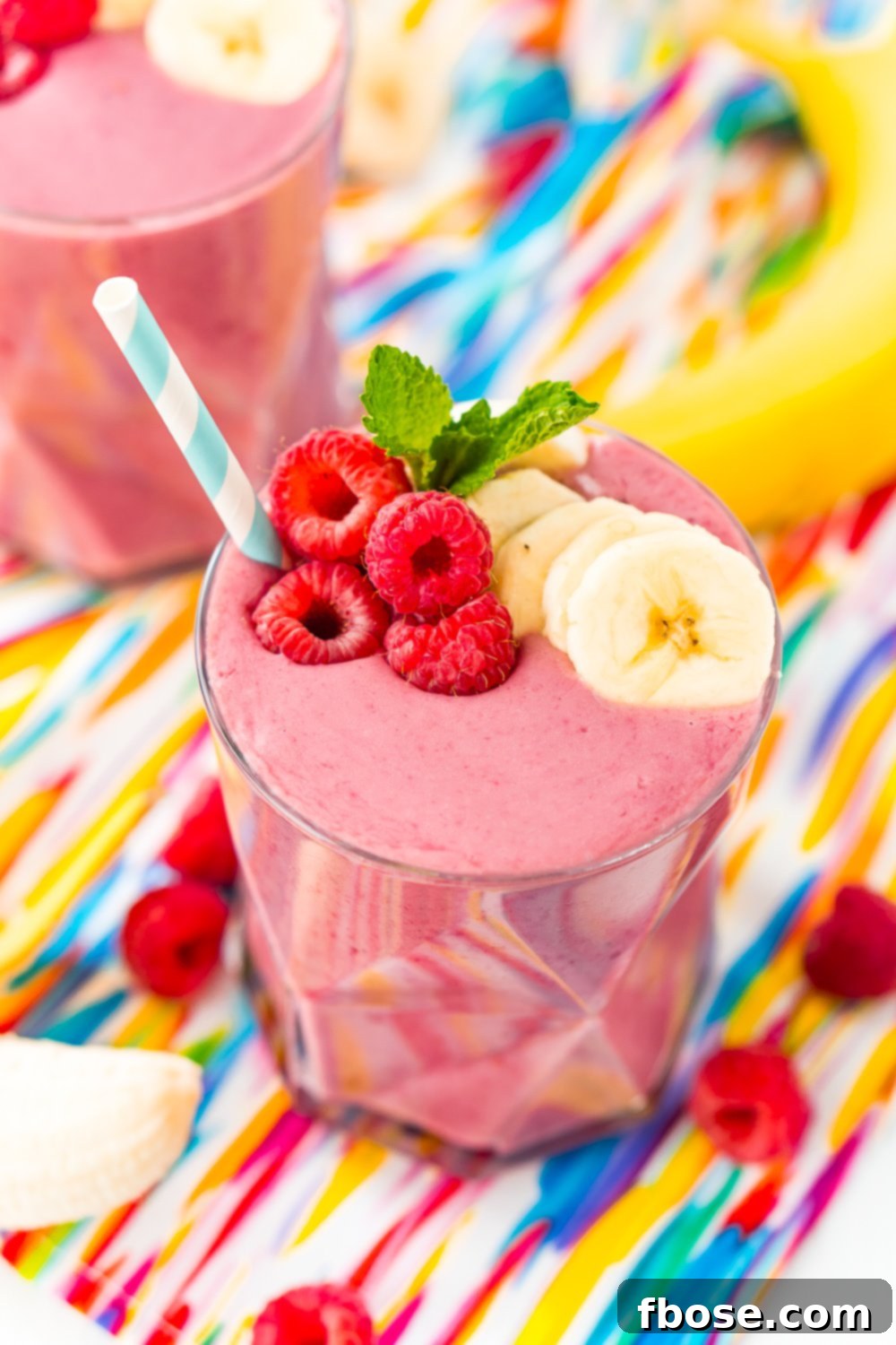 Berry Banana Bliss 2 Raspberry Banana Smoothie topped with banana slices, mint, and fresh raspberries.