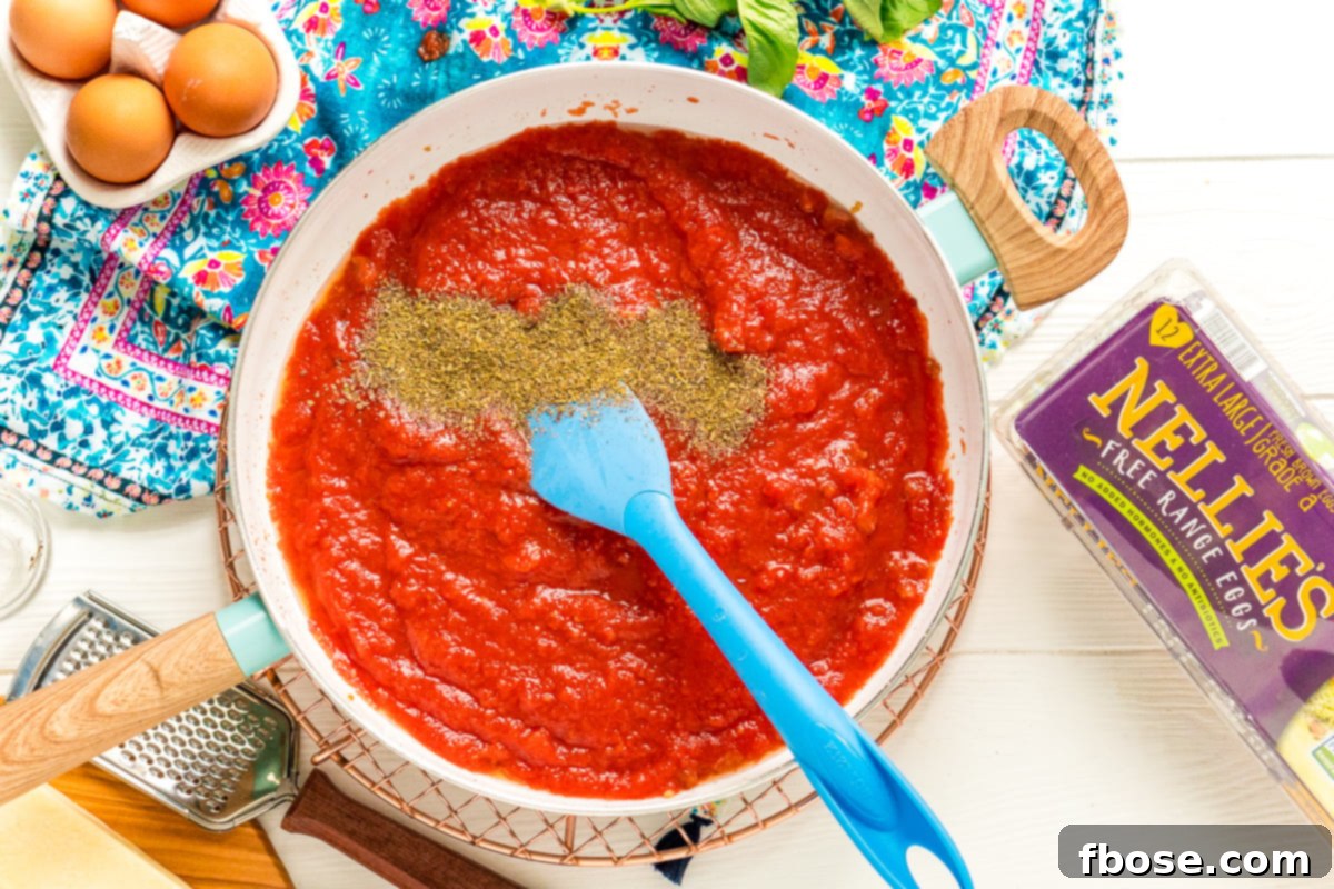 Italian Seasoning being added to a fry pan with tomato sauce. A sprinkle of Italian seasoning being added to the simmering tomato sauce, infusing it with classic Mediterranean flavors.