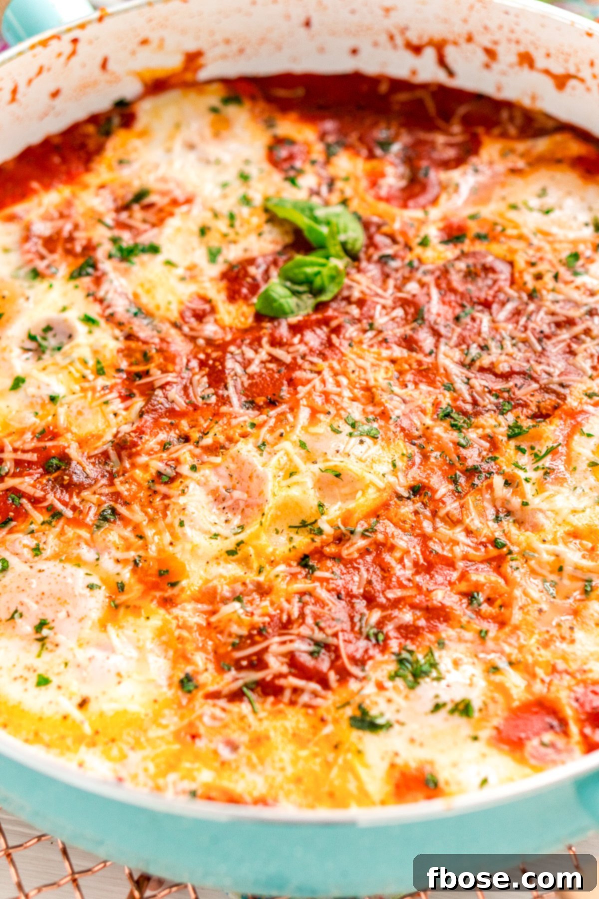 Close up photo of a skillet with Eggs In Purgatory. A detailed shot revealing the perfectly cooked eggs nestled within the rich tomato sauce, showcasing the vibrant colors and appealing textures of the dish.