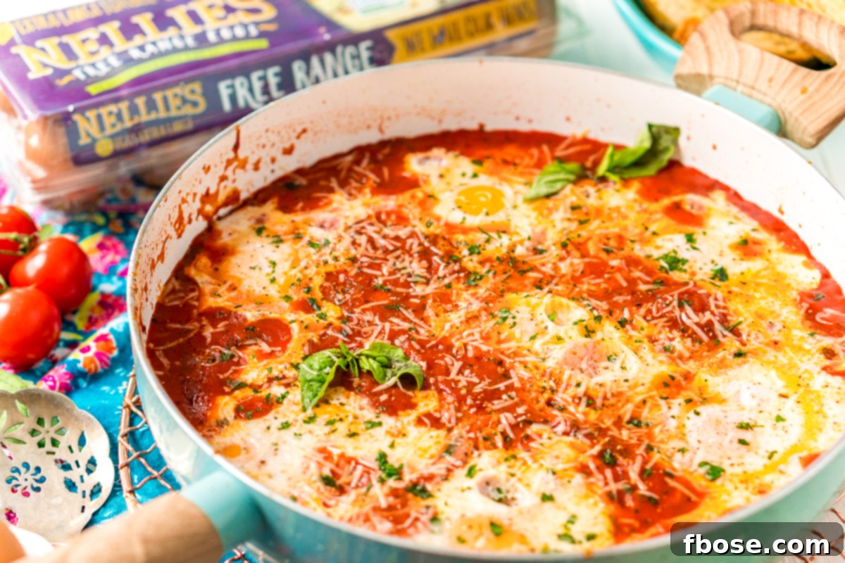 Eggs In purgatory in a blue skillet. A rustic blue skillet filled with bubbling Eggs in Purgatory, ready for serving, highlighting the enticing texture of the sauce and eggs.