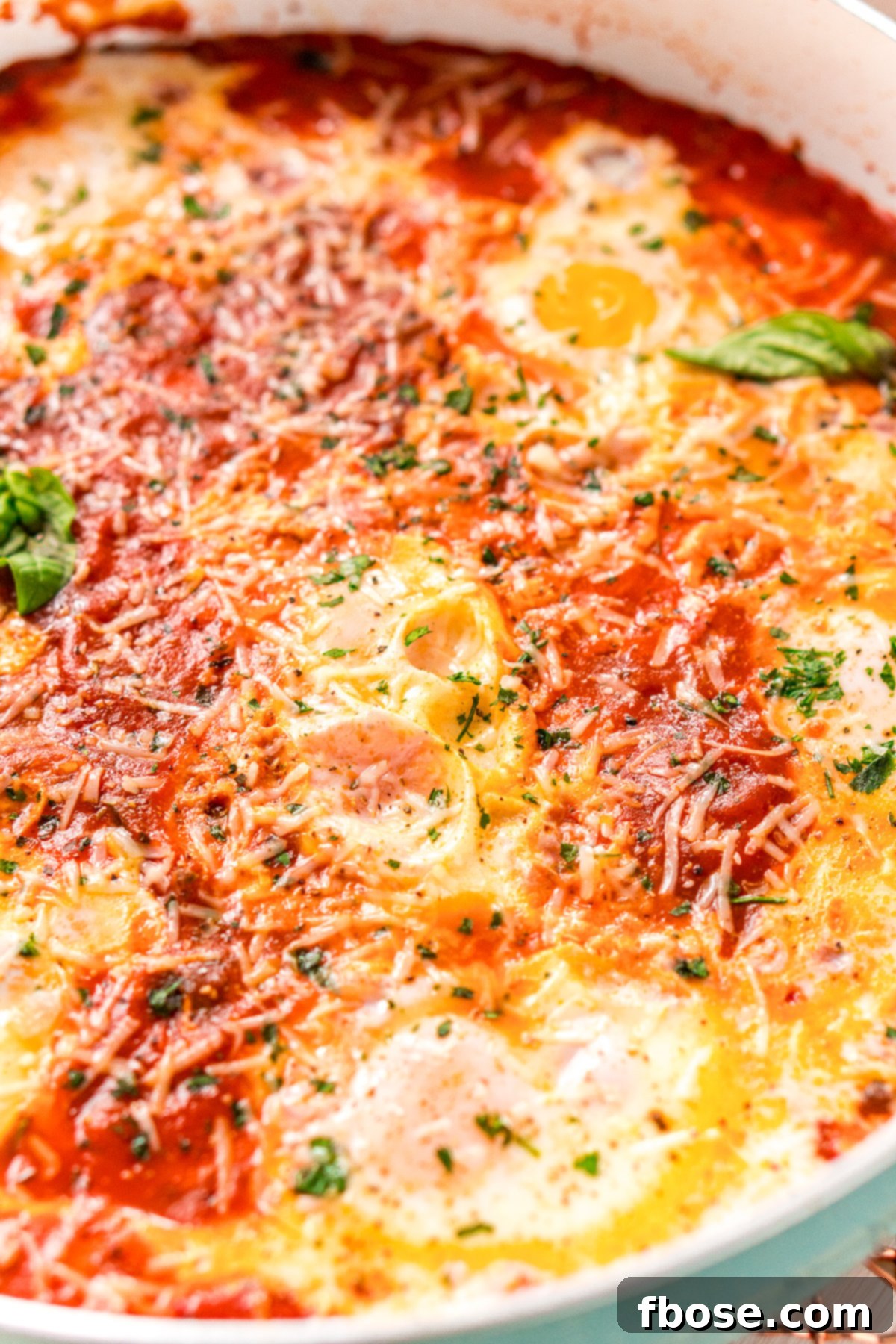 Close up photo of Eggs In Purgatory. A detailed and inviting close-up of a serving of Eggs in Purgatory, highlighting the vibrant sauce, tender eggs, and enticing garnishes.