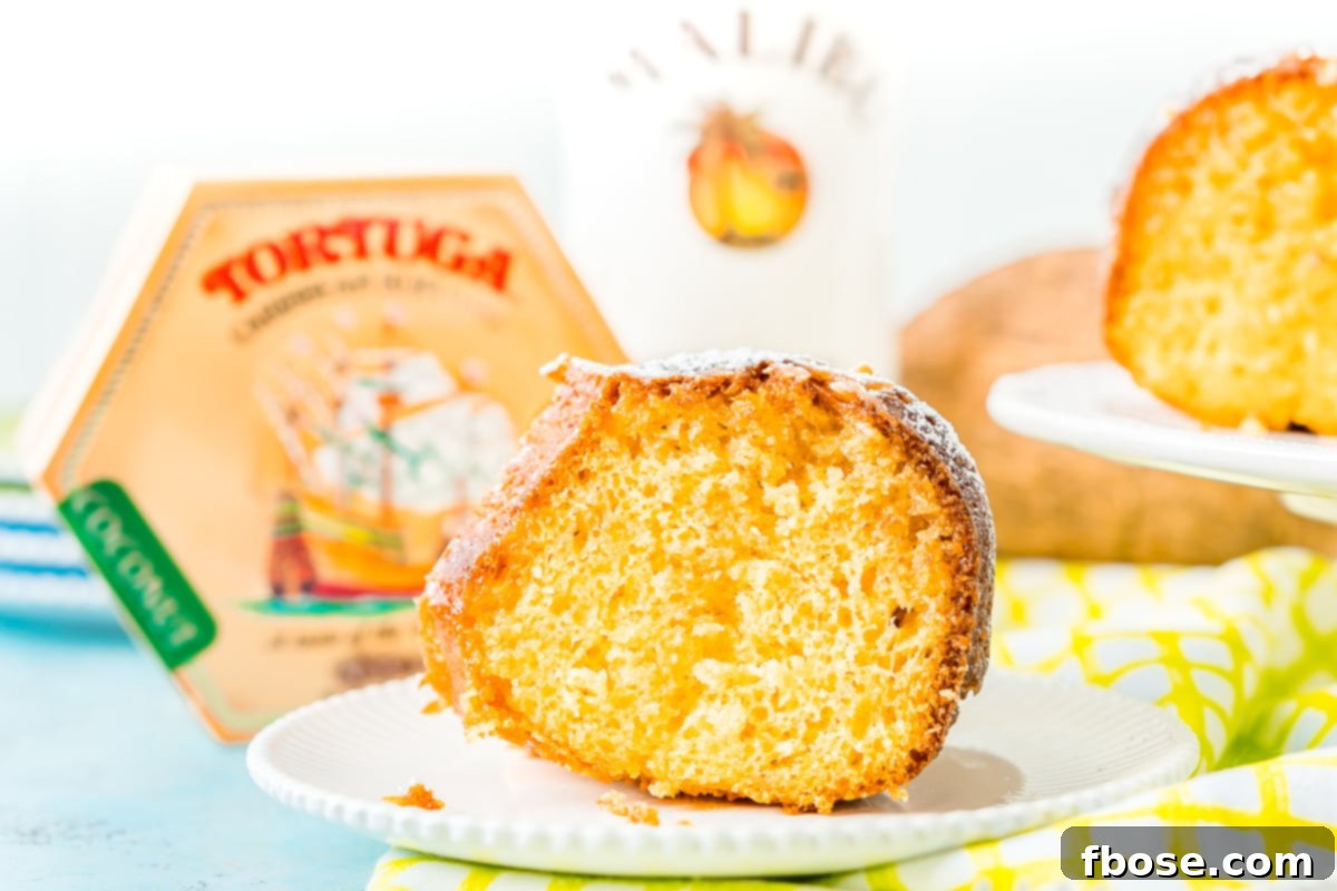 Caribbean Coconut Rum Bliss 4 Slice of rum cake on a white plate with a Tortuga Rum Cake box in the background.