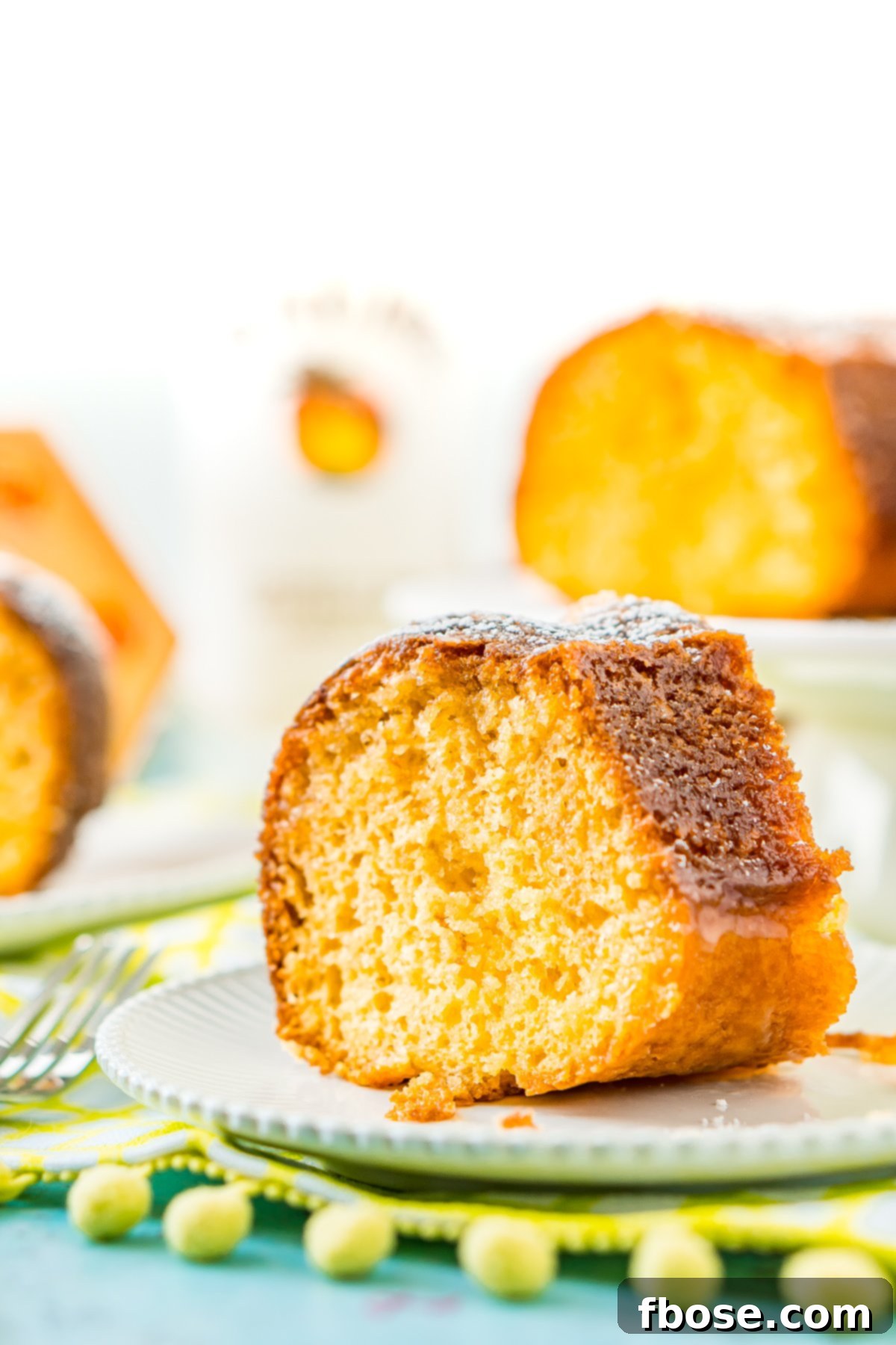 Caribbean Coconut Rum Bliss 7 Slice of rum cake on a white cake with more slices on the background.