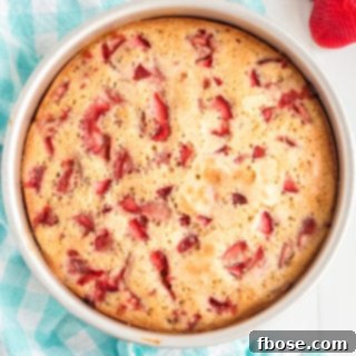 Overhead photo of baked strawberry cake on a blue napkin.