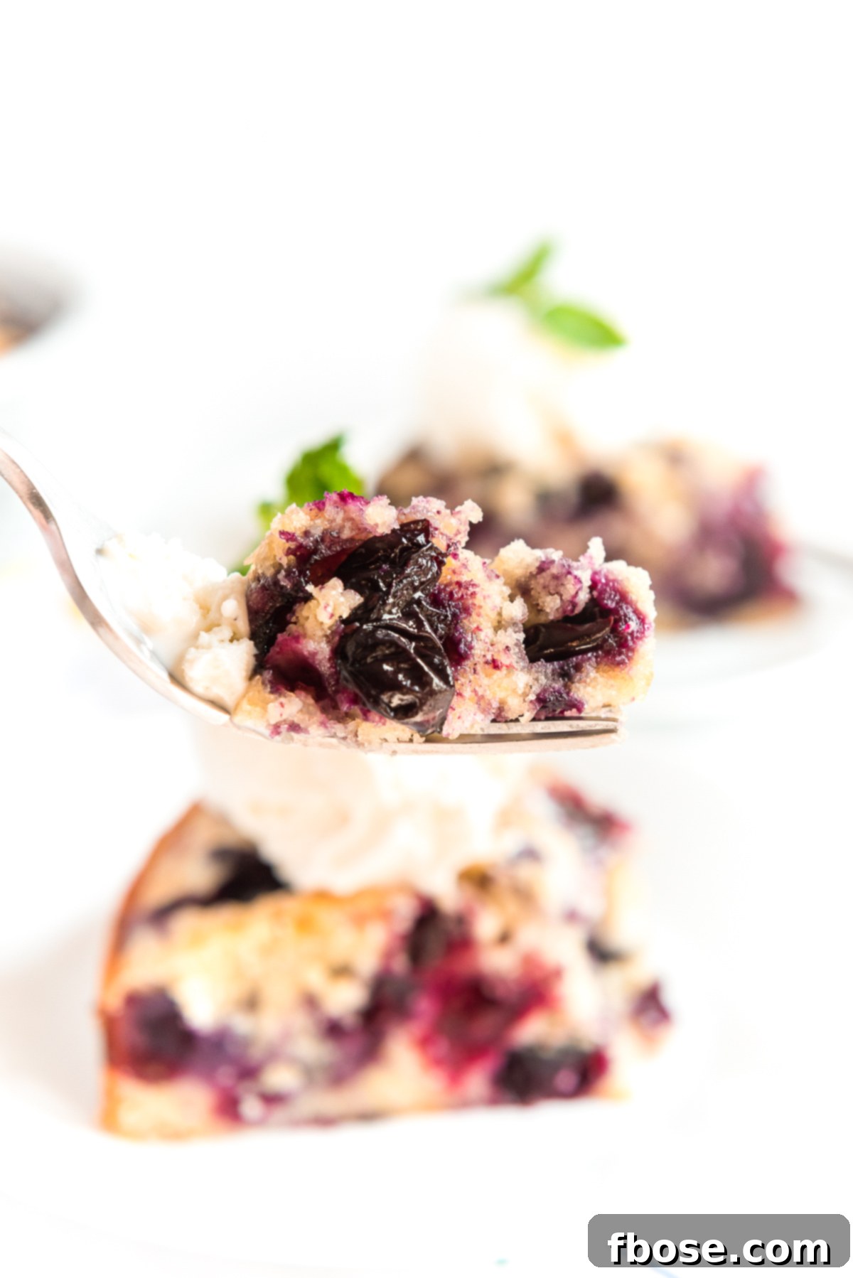 Bite of blueberry cake on a fork.
