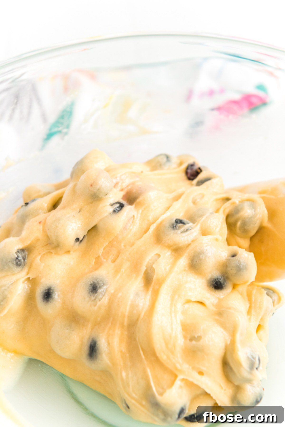 Blueberries being folded into cake batter to make blueberry cake.
