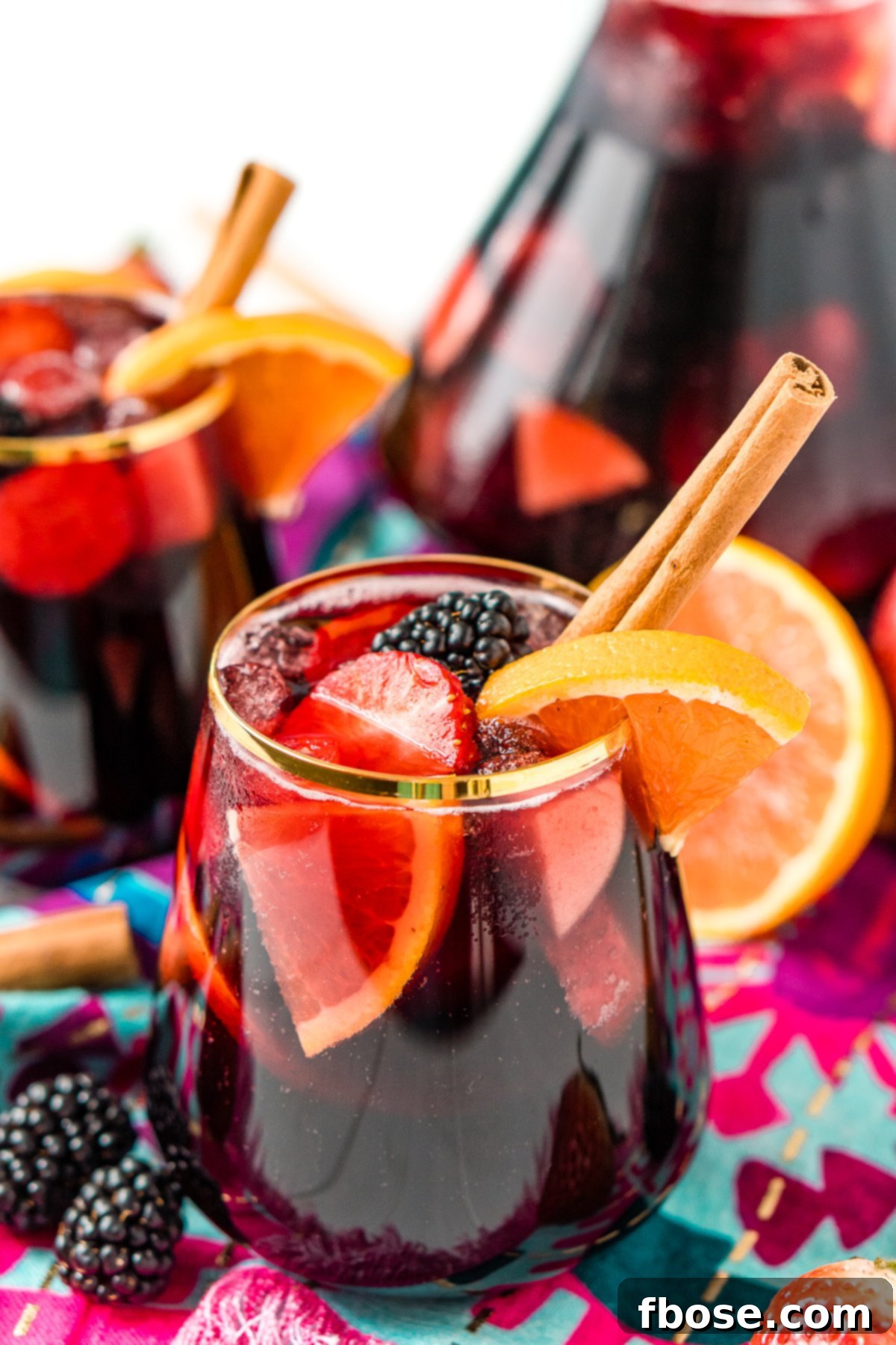 A close-up view of a glass brimming with vibrant red wine sangria, highlighting the rich color and inviting texture of the fruit-infused cocktail.